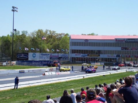 1978 Ford F-250 - A drag racing event is underway with cars lined up on the track and spectators in the stands.