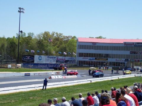 1978 Ford F-250 - Cars line up at the start of a drag race, with spectators in the foreground and a grandstand in the background.