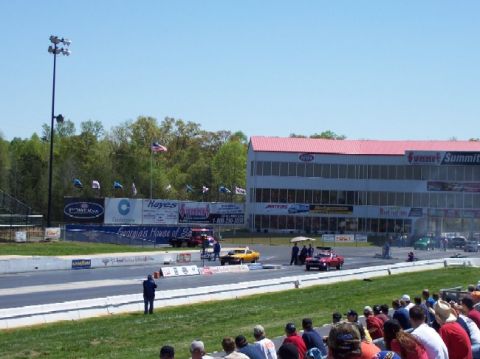 1978 Ford F-250 - A drag racing event is underway with cars on the track and spectators in the stands.