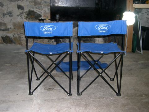 1994 Ford Bronco - Two Ford Bronco branded folding chairs are displayed in a room with stone walls.