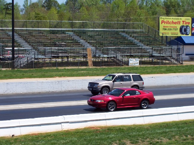 red sports car and silver SUV racing on a drag strip