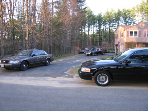 1991 Ford LTD Crown Victoria - Several Ford Crown Victoria sedans are parked in a driveway next to a house.