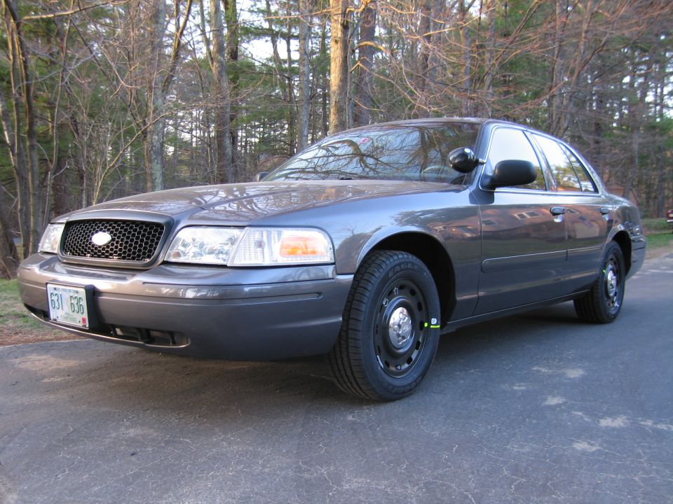 Gray Ford Crown Victoria with black grille and steel wheels parked on asphalt