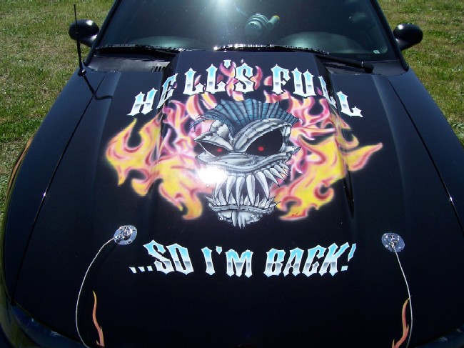 Black hood with airbrushed flaming monster mural reading Hell's Full So I'm Back, with hood pins