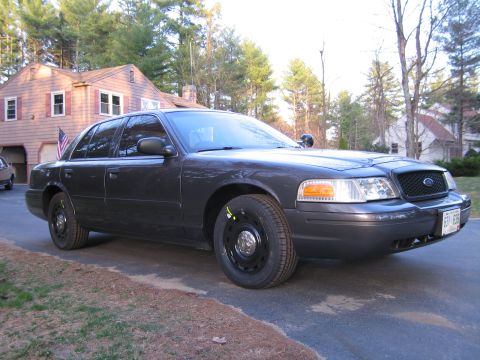1991 Ford LTD Crown Victoria - Dark gray Ford Crown Victoria Police Interceptor parked in a driveway with a house in the background.