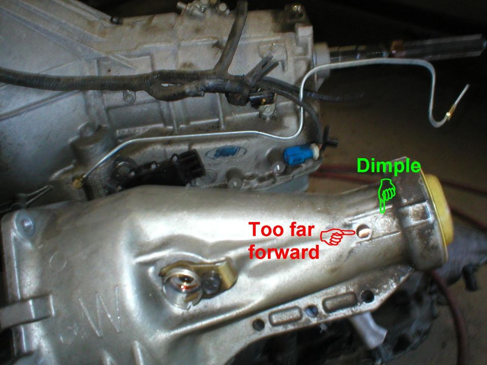 I drilled too far forward - I should have drilled in the dimple of the casting.  Considering the rotation of the driveshaft & the location of the drain in the bushing, I'll do the next one on the passenger side, and  wrap the brake line over.