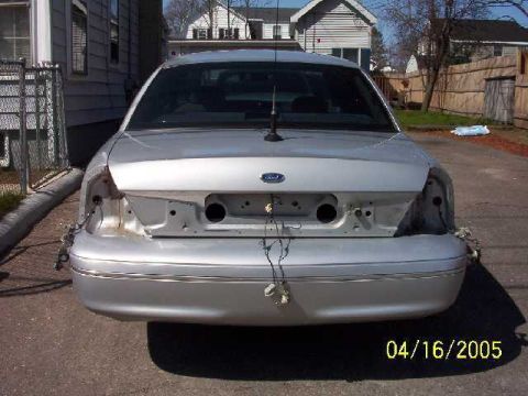 1999 Ford Crown Victoria - Rear view of a 1999 Ford Crown Victoria showing missing taillights and bumper damage.
