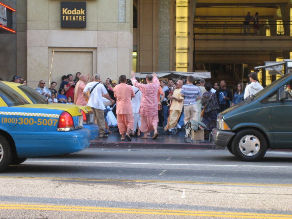 People gathered in front of the Kodak Theatre with a taxi and a van nearby