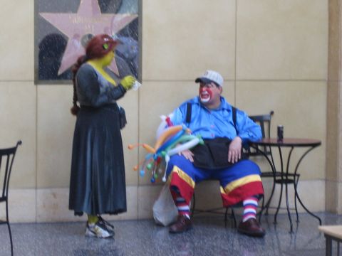 1968 Ford Mustang - A person dressed as Shrek interacts with a clown sitting at a table with a balloon animal.