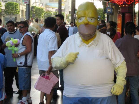 1968 Ford Mustang - A person in a Homer Simpson costume stands on a sidewalk with other people in the background.