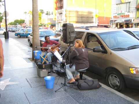 1968 Ford Mustang - Street musicians perform on the Hollywood Walk of Fame, with a minivan parked nearby.