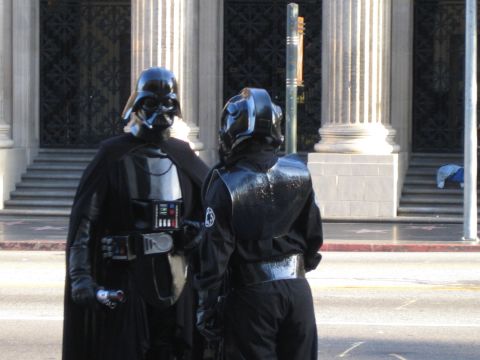 1968 Ford Mustang - Two individuals in Star Wars costumes stand on a street, with a building and stairs in the background.