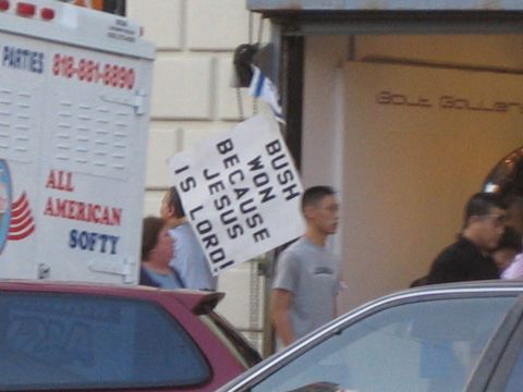1968 Ford Mustang - A sign reading 'BUSH WON BECAUSE JESUS IS LORD!' is held up near an ice cream truck and other vehicles.