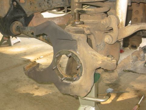 1986 Ford Bronco - This image shows a close-up of a vehicle's suspension system, likely a ball joint assembly, on jack stands.