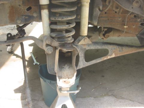 1986 Ford Bronco - Close-up of a vehicle's front suspension system, showing disassembled ball joint components.