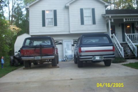 1979 Ford F-150 - Two Ford Broncos are parked in a driveway in front of a suburban house.