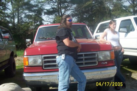 1979 Ford F-150 - A red Ford F-series truck is parked outdoors with two people nearby. Another white truck is visible.