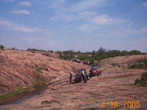1986 Ford Bronco - Several off-road vehicles navigate a challenging rocky landscape, their capabilities in terrain.