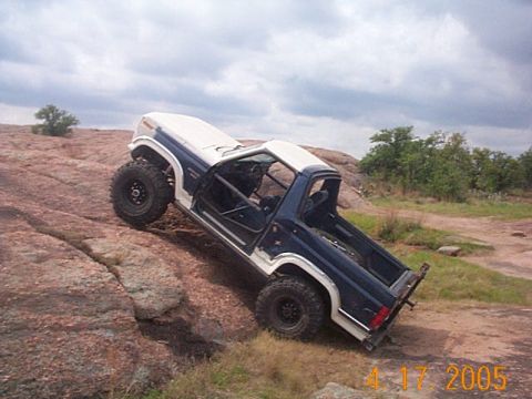 1986 Ford Bronco - A modified Ford Bronco navigates a rocky terrain, its off-road capabilities.