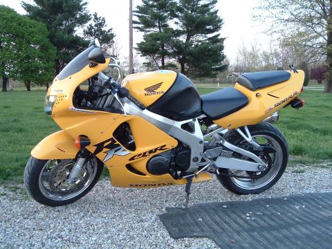 2002 Harley-Davidson Sportster Custom - A yellow Honda CBR900RR motorcycle is parked on a gravel surface outdoors.