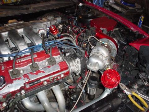 1996 Ford Probe - Close-up view of a modified engine bay, showing a turbocharger and associated plumbing.