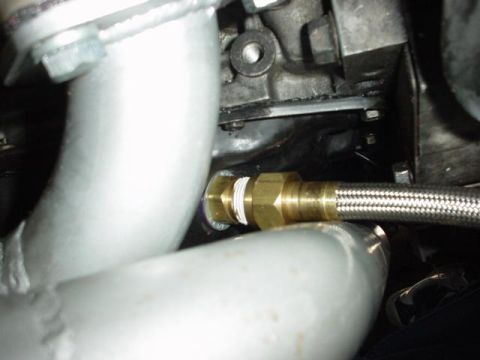 1996 Ford Probe - Close-up view of a braided hose attached to an engine component.