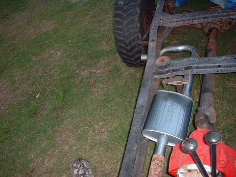 1976 Ford F-150 - Vehicle frame components including an exhaust muffler and a tire are visible in this close-up shot.