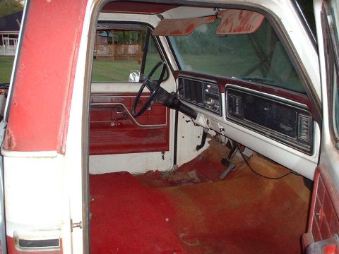 1976 Ford F-150 - The interior of a pickup truck, a red carpet and a dashboard with a "Ranger" badge, appears to be from the mid-1970s.