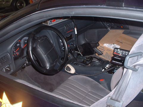 1999 Ford Crown Victoria - Interior view of a police car, likely a 1995 Chevrolet Camaro, equipped with communication and control devices.