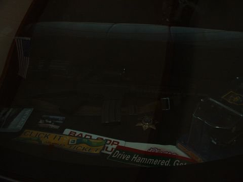 1999 Ford Crown Victoria - The interior of a car is shown, decorated with an American flag and several bumper stickers.
