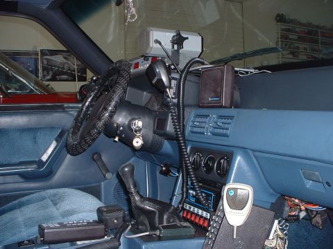 1999 Ford Crown Victoria - The interior of a police vehicle is shown, various communication devices and a manual transmission.