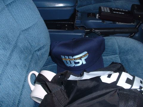 1999 Ford Crown Victoria - Interior view of a vehicle showing a Washington State Patrol cap, mug, and radio console.