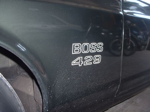 1999 Ford Crown Victoria - The 'BOSS 429' emblem is clearly visible on the fender of this classic car, with a motorcycle reflected in the paint.