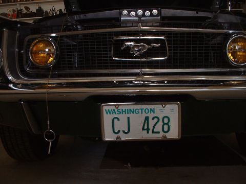 1999 Ford Crown Victoria - Front view of a 1967 Ford Mustang, its iconic grille emblem and a Washington state license plate.