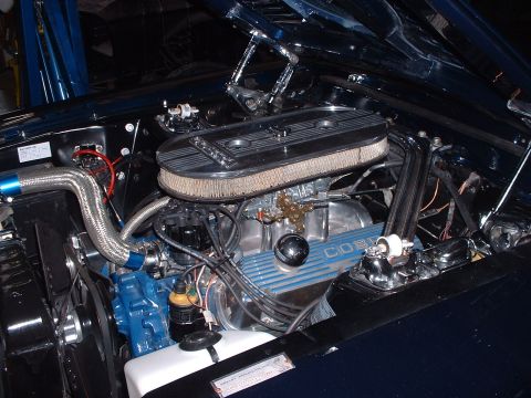 1999 Ford Crown Victoria - Close-up of a V8 engine, a chrome air cleaner and "COBRA" branding on the valve covers.
