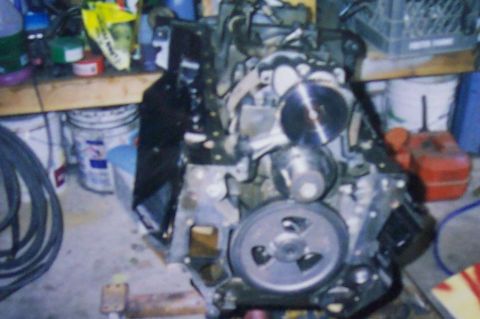 1994 Ford F-150 - Engine components are visible in a workshop environment with various tools and containers in the background.