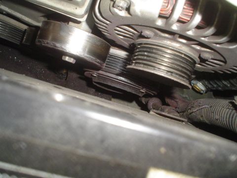 1993 Ford Taurus - Close-up view of the engine belt tensioner and alternator pulley system.