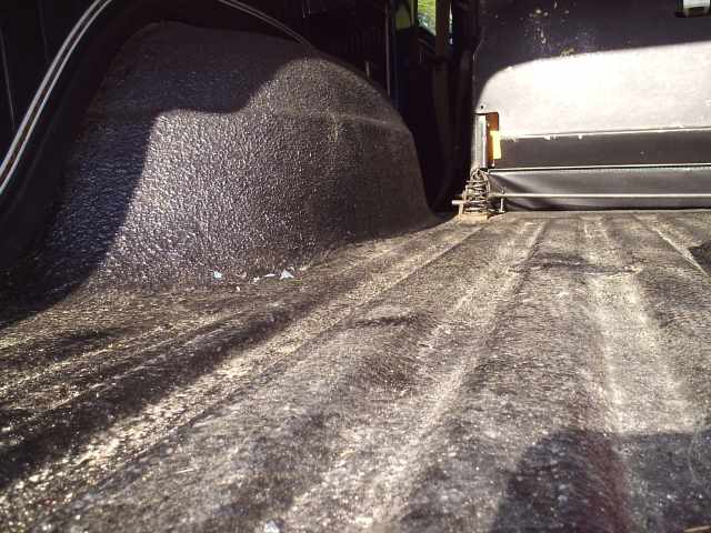 Textured black bedliner coating on an SUV rear cargo floor and wheel well