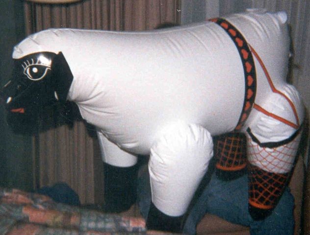 Inflatable sheep toy with black face and heart-patterned harness