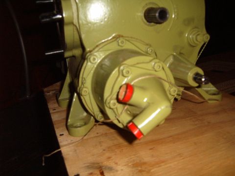 1988 Ford Bronco - Close-up view of a green painted mechanical part with red capped fittings.