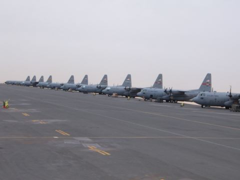 1988 Ford Bronco - Multiple US Air Force cargo planes are lined up on an airfield under a hazy sky.