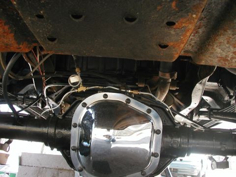 1994 Ford Bronco - Underside view of a vehicle's rear differential, a chrome cover and brake line modifications.