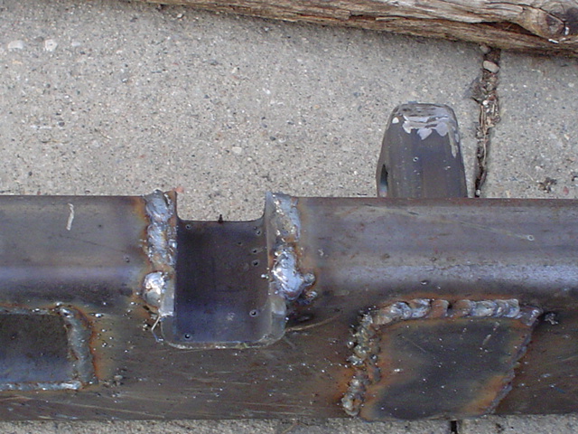 Close-up of MIG weld beads on a bare steel fabricated bumper center section