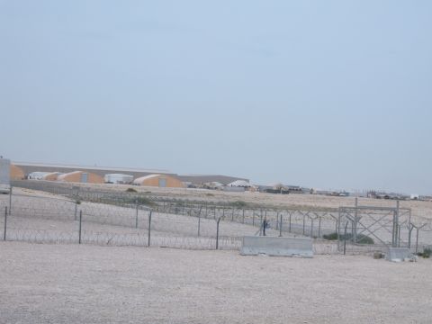 1988 Ford Bronco - A wide view of a desolate area with industrial structures and fencing under a pale sky.
