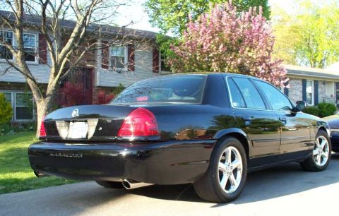 1998 Ford Crown Victoria - A black sedan with a 'Marauder' badge is parked on a residential street.
