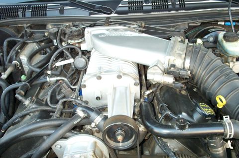 1998 Ford Crown Victoria - Close-up view of a supercharged engine bay, a prominent silver supercharger and various hoses and components.
