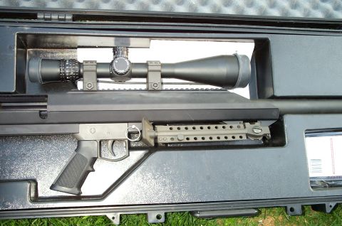 1998 Ford Crown Victoria - A sniper rifle with a scope is stored in a black case, with the Supermotors logo visible at the bottom.