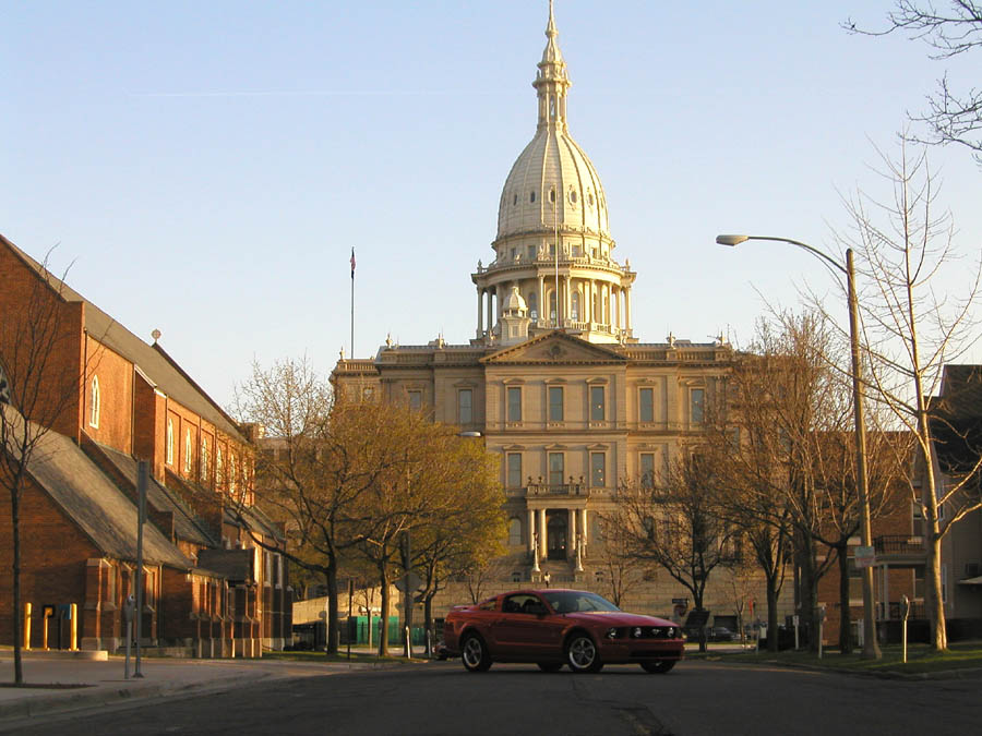 Red 2005 Ford Mustang parked in front of the Michigan State Capitol building