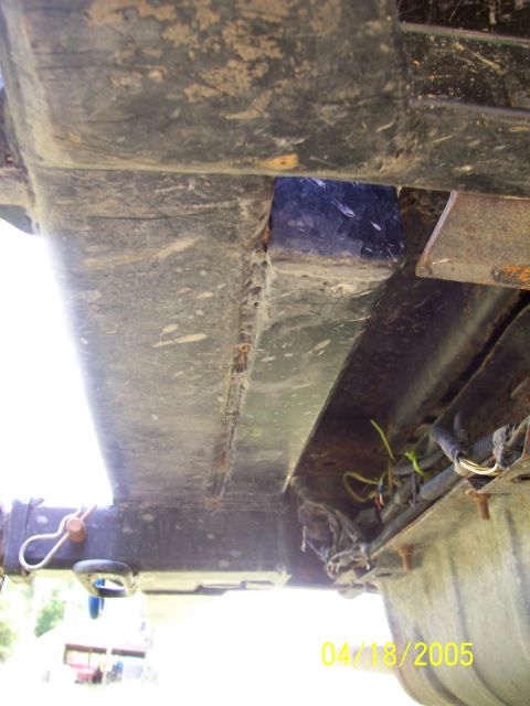 1987 Ford Bronco - Undercarriage view shows a trailer hitch and exposed wiring harness, with visible rust and dirt.