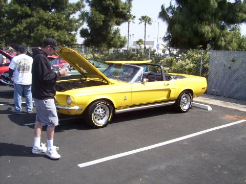 2002 Ford Mustang - Yellow 1968 Ford Mustang convertible parked outdoors with hood open, people looking at it.